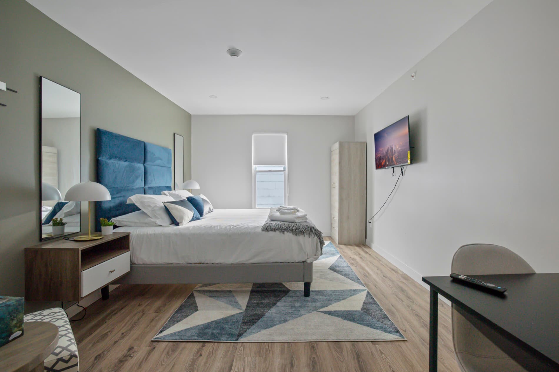 A standard suite at The Columbus Hotel, with a made queen bed and a window