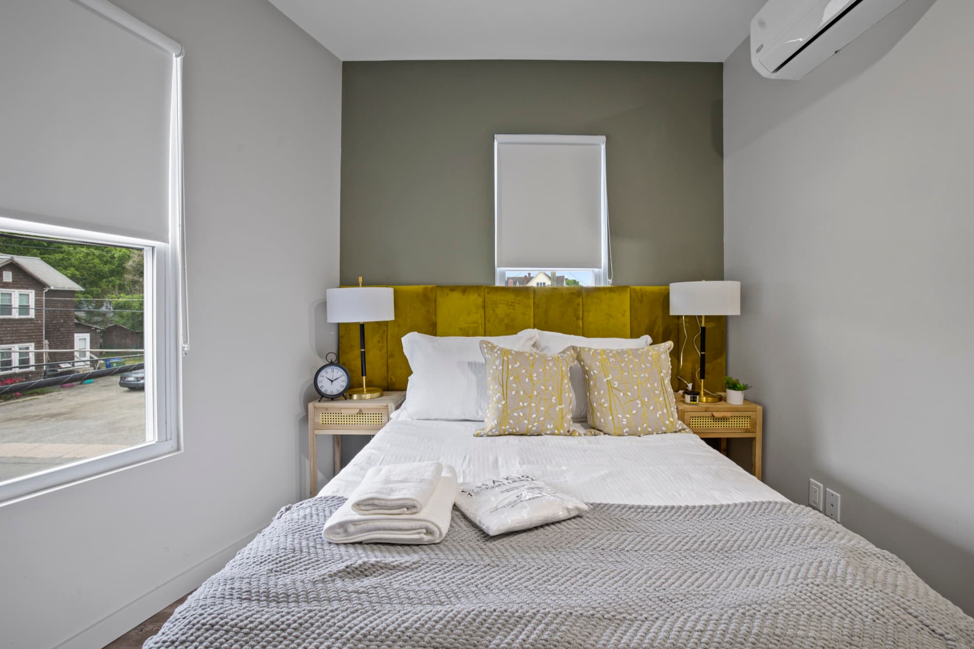 King bed with an olive velvet headboard and warm natural light