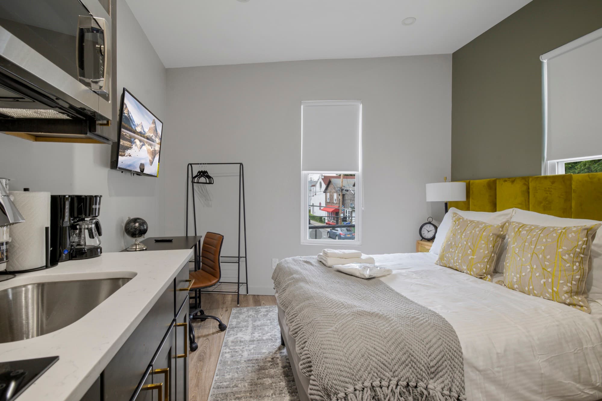 Full room with a desk workspace and the kitchenette beyond