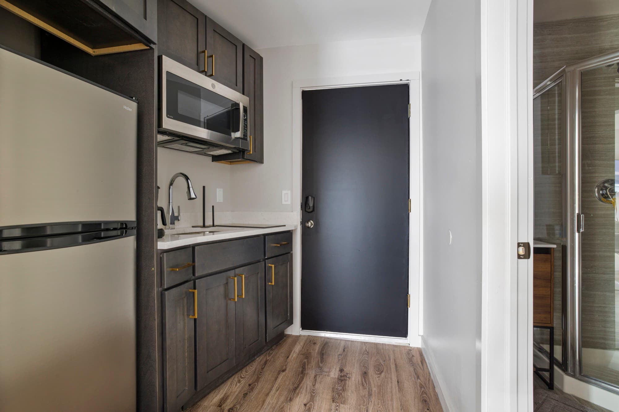 Kitchenette with dark shaker cabinets and gold pulls